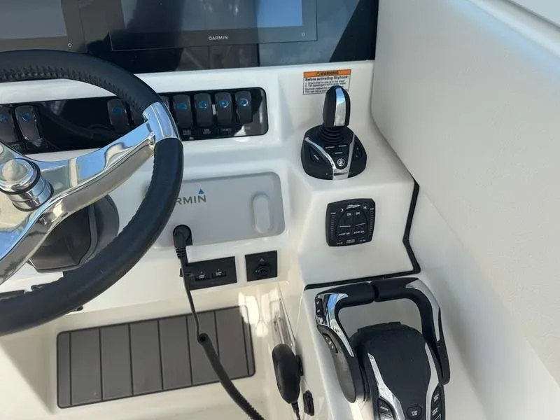 Slide: The Image of 2025 Sailfish 316 DC boat dashboard with steering wheel and control panel. - 10