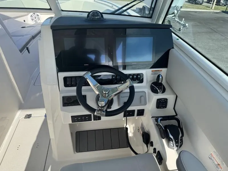 Slide: The Image of Helm of 2025 Sailfish 316 DC boat with modern controls and dual screens. - 11