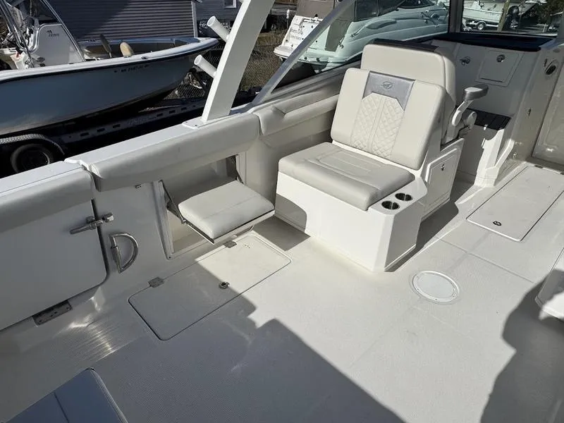 Slide: The Image of 2025 Sailfish 316 DC boat interior with white seating and cup holders. - 2