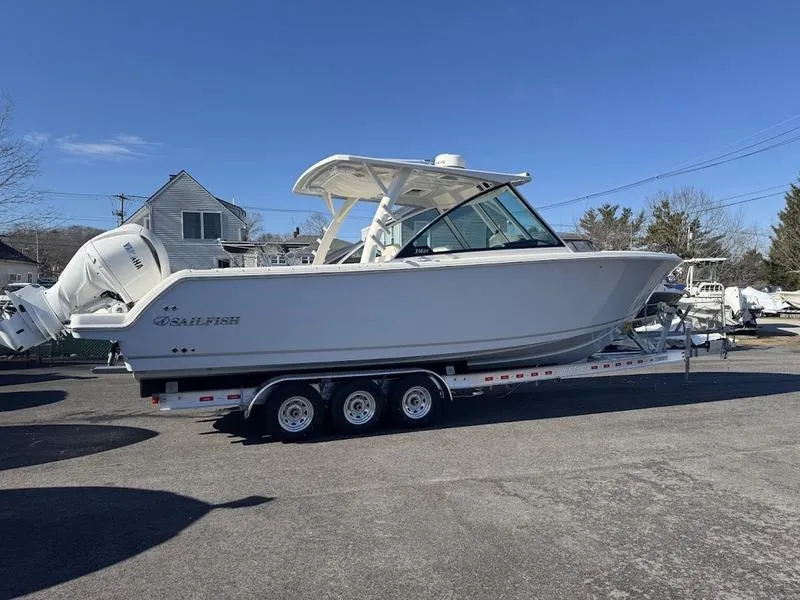 Slide: The Image of 2025 Sailfish 316 DC boat on a trailer, parked outdoors under clear blue sky. - 22