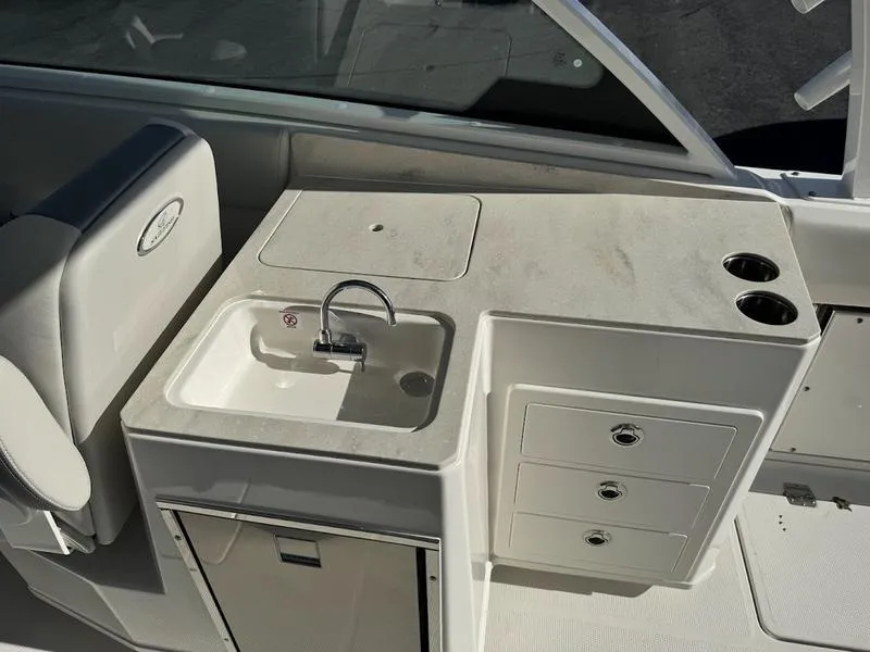 Slide: The Image of 2025 Sailfish 316 DC boat interior with sink, storage drawers, and cup holders. - 4