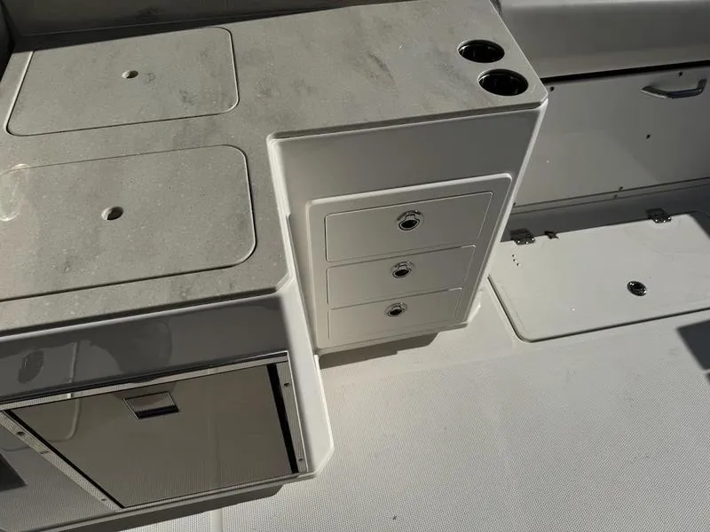 Slide: The Image of 2025 Sailfish 316 DC boat interior with storage compartments and cup holders. - 6