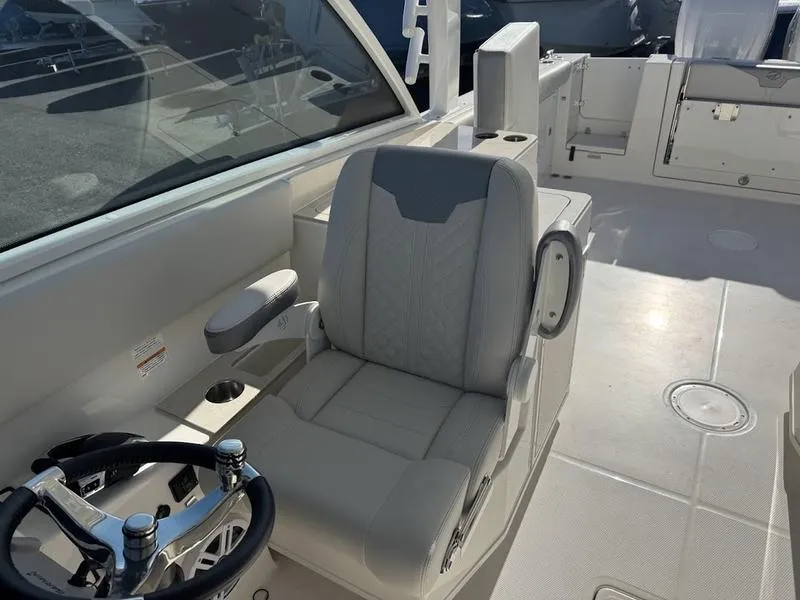 Slide: The Image of 2025 Sailfish 316 DC boat interior with steering wheel and seating area. - 9