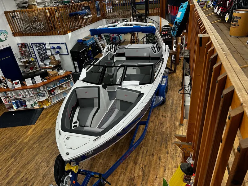 Slide: The Image of 2025 Cobalt CS23 Surf boat displayed in a showroom with wooden flooring. - 3