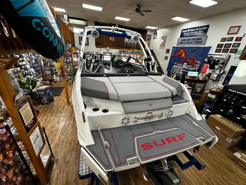 Slide: The Image of 2025 Cobalt CS23 Surf boat displayed in a showroom, featuring sleek design and surf platform. - 5
