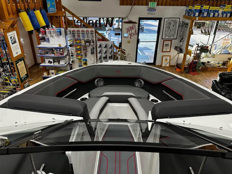 Slide: The Image of 2025 Cobalt CS23 Surf boat interior in showroom, featuring sleek seating and modern design. - 7