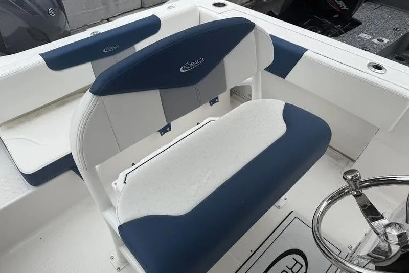 Slide: The Image of 2025 Robalo R 202 EX boat interior with blue and white seating and steering wheel. - 12