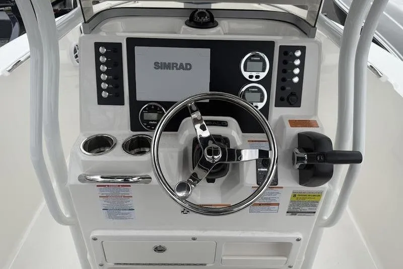 Slide: The Image of 2025 Robalo R 202 EX boat dashboard with Simrad display and steering wheel. - 9