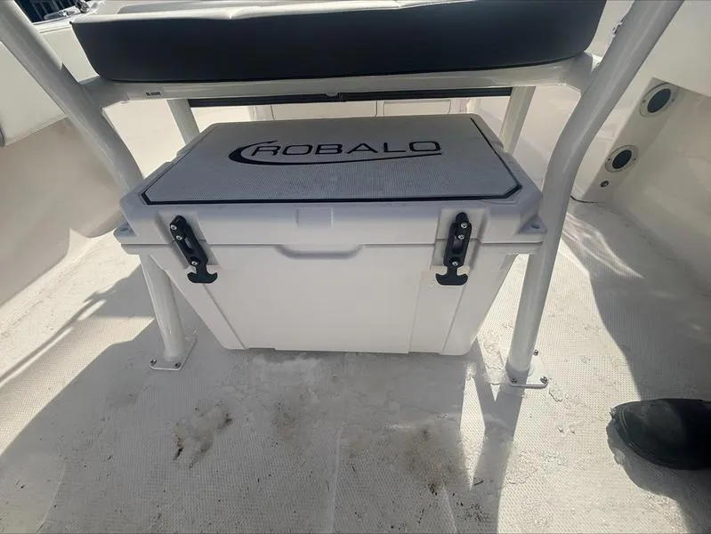Slide: The Image of 2025 Robalo R 180 CC boat cooler under seat, white with logo. - 10