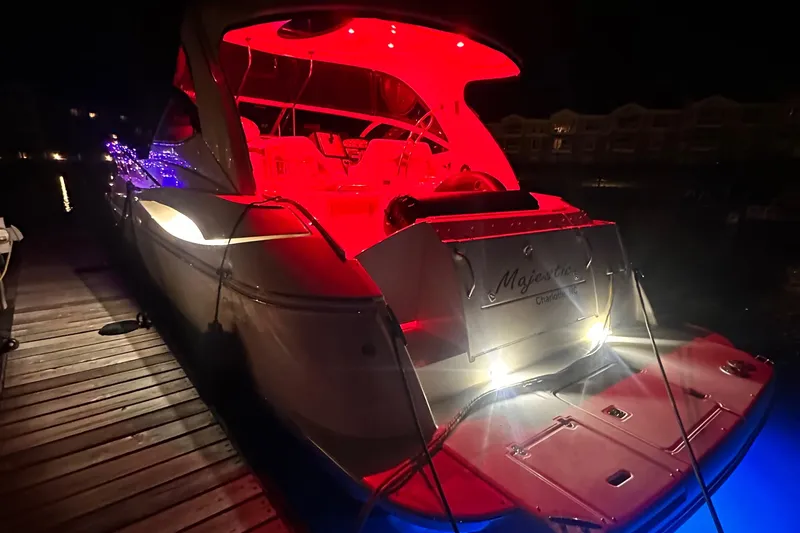Slide: The Image of 2006 Cruisers Yachts 420 Express with vibrant red and blue lighting at night. - 14
