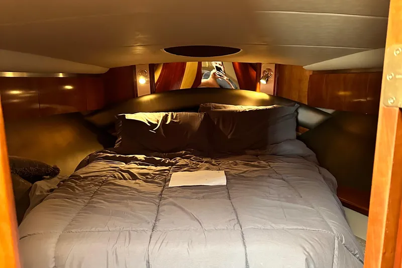 Slide: The Image of 2006 Cruisers Yachts 420 Express cabin with cozy bed and warm lighting. - 20