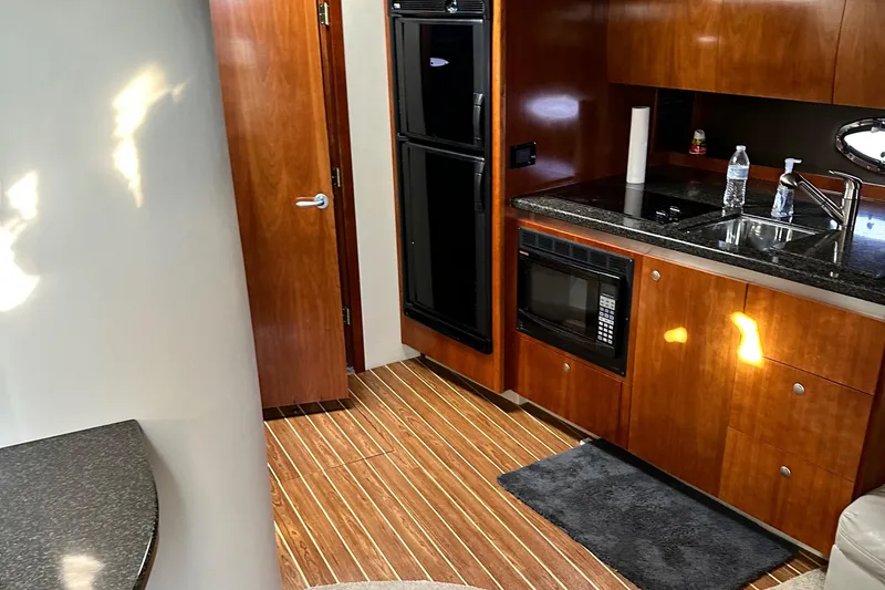 Slide: The Image of Interior of 2006 Cruisers Yachts 420 Express with wood cabinetry and modern kitchen amenities. - 21