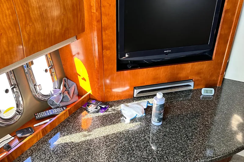 Slide: The Image of 2006 Cruisers Yachts 420 Express interior with TV, granite countertop, and porthole windows. - 22