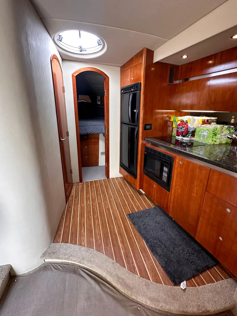 Slide: The Image of 2006 Cruisers Yachts 420 Express interior with wood flooring and modern kitchen amenities. - 28