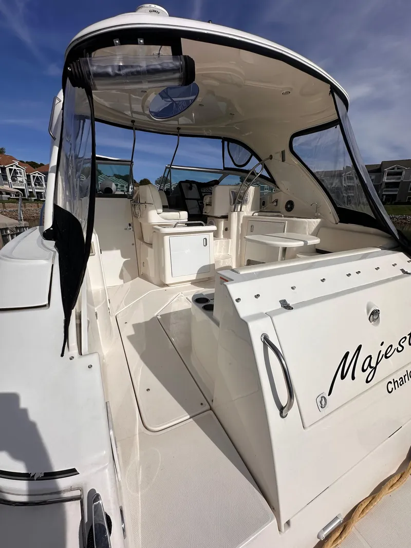 Slide: The Image of 2006 Cruisers Yachts 420 Express, spacious deck, luxury seating, clear skies, marina backdrop. - 3