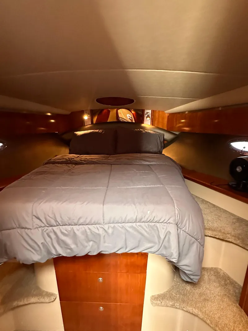 Slide: The Image of 2006 Cruisers Yachts 420 Express cabin with cozy bed and wooden interior. - 32