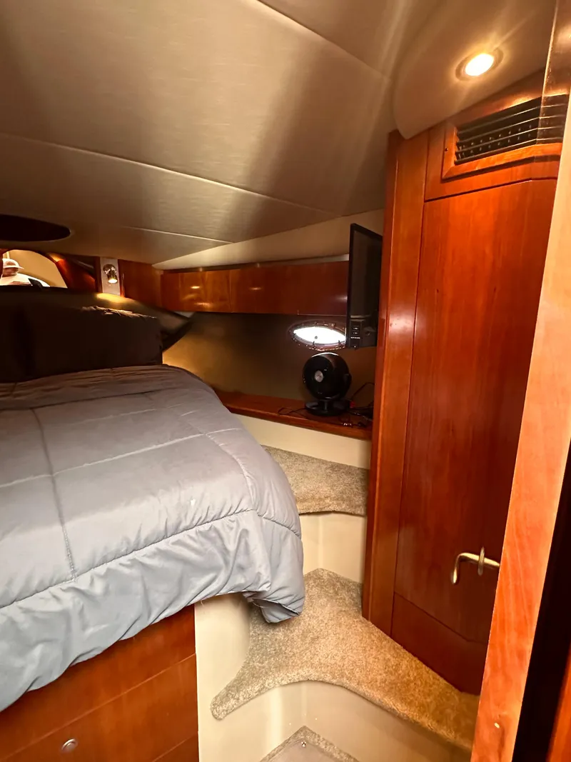 Slide: The Image of 2006 Cruisers Yachts 420 Express cabin interior with bed and wooden cabinetry. - 33