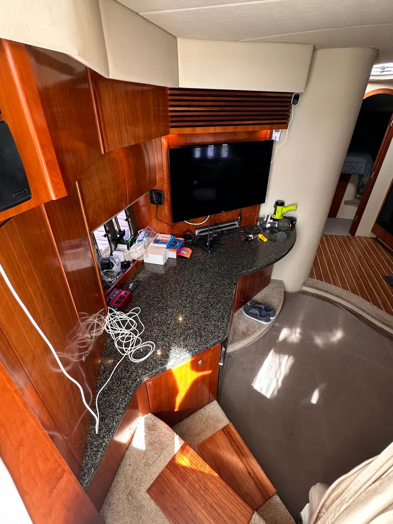 Slide: The Image of 2006 Cruisers Yachts 420 Express interior with TV, wooden cabinetry, and carpeted flooring. - 42