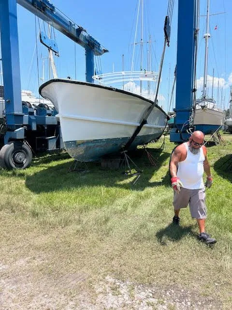 The Image of Man walking near a 1969 Webbers Cove 39 boat in a shipyard. - 0