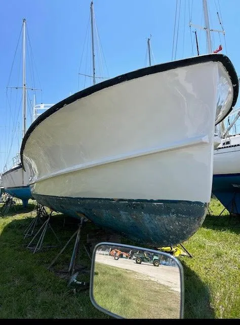 Slide: The Image of 1969 Webbers Cove 39 boat on land, surrounded by other boats, under clear blue sky. - 9
