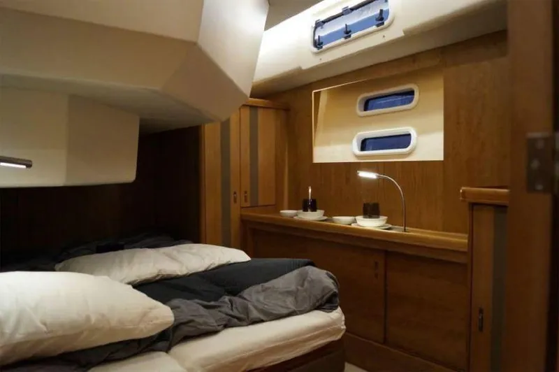 Slide: The Image of Luxurious cabin interior of 2025 Moody 54 DS yacht with cozy bedding and wooden furnishings. - 27