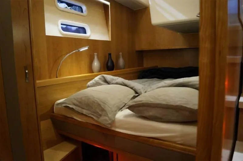 Slide: The Image of Cozy cabin interior of 2025 Moody 54 DS yacht with wooden finish and comfortable bedding. - 28
