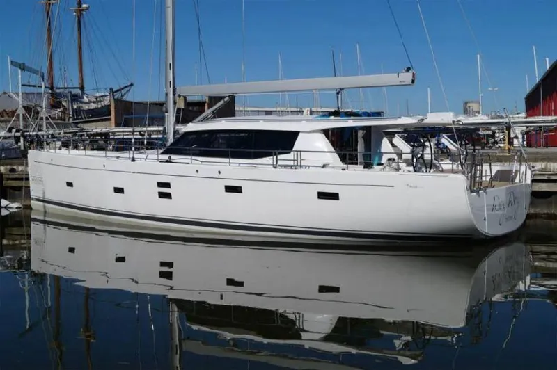 Slide: The Image of Sleek 2025 Moody 54 DS yacht docked in a marina, reflecting on calm water. - 7