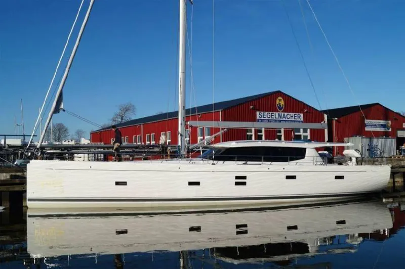 Slide: The Image of 2025 Moody 54 DS yacht docked near red building, clear blue sky. - 8