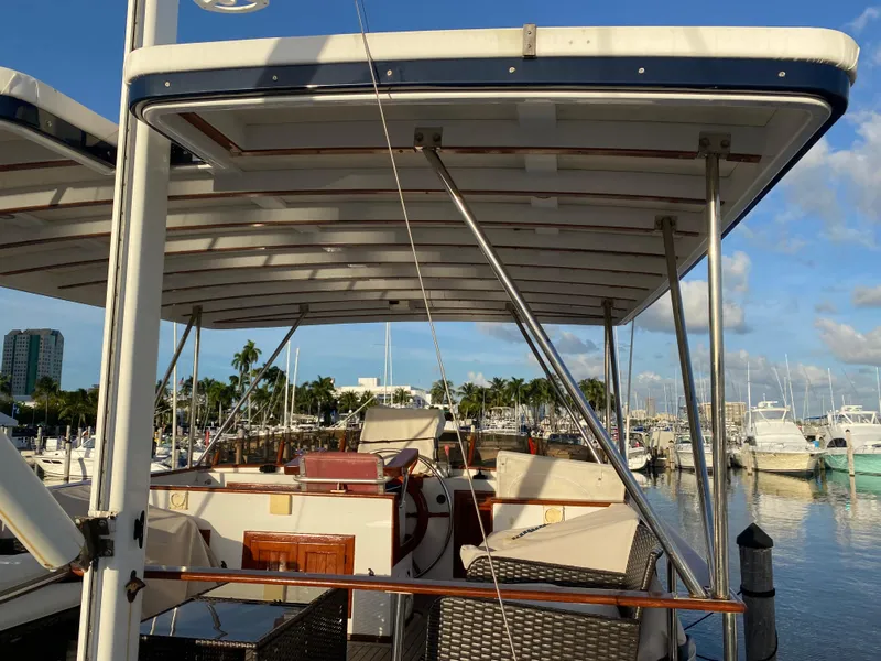 Slide: The Image of 1983 DeFever 41 yacht docked at marina with clear skies and palm trees. - 11