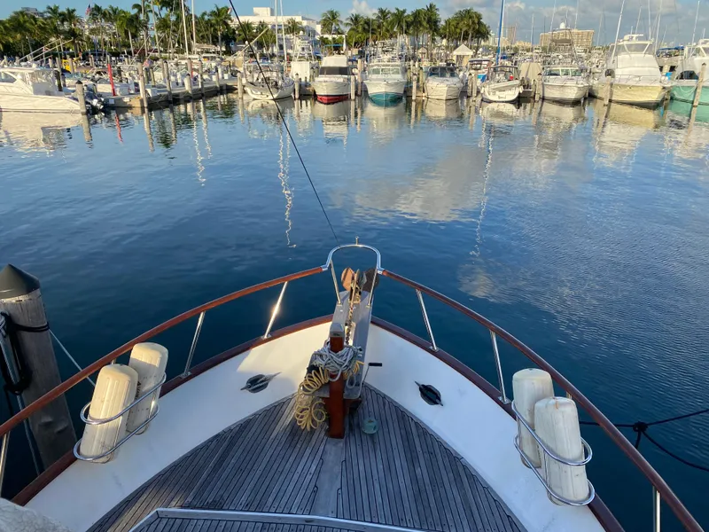 Slide: The Image of Bow view of 1983 DeFever 41 yacht docked in a marina with calm waters. - 12