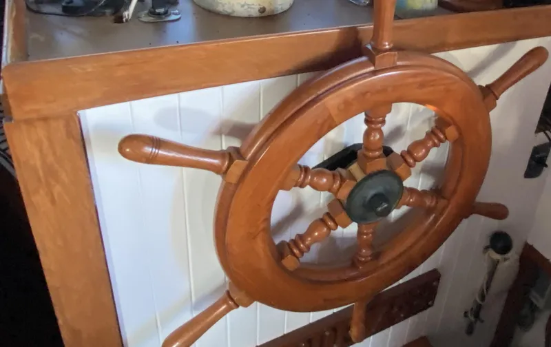 Slide: The Image of Wooden ship wheel on 1983 DeFever 41 yacht, showcasing classic nautical design. - 17