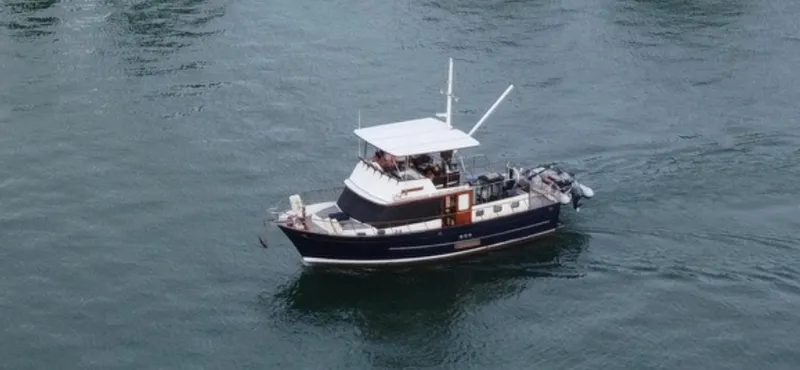 Slide: The Image of 1983 DeFever 41 yacht cruising on calm waters. - 2