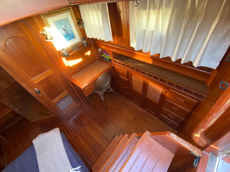 Slide: The Image of 1983 DeFever 41 yacht interior with wooden furnishings and desk area. - 24