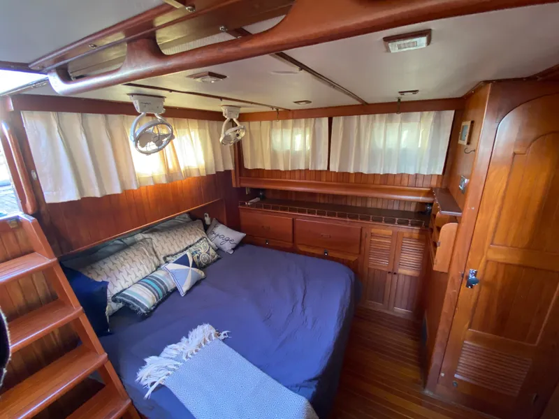 Slide: The Image of Cozy cabin interior of 1983 DeFever 41 yacht with wood paneling and comfortable bedding. - 25