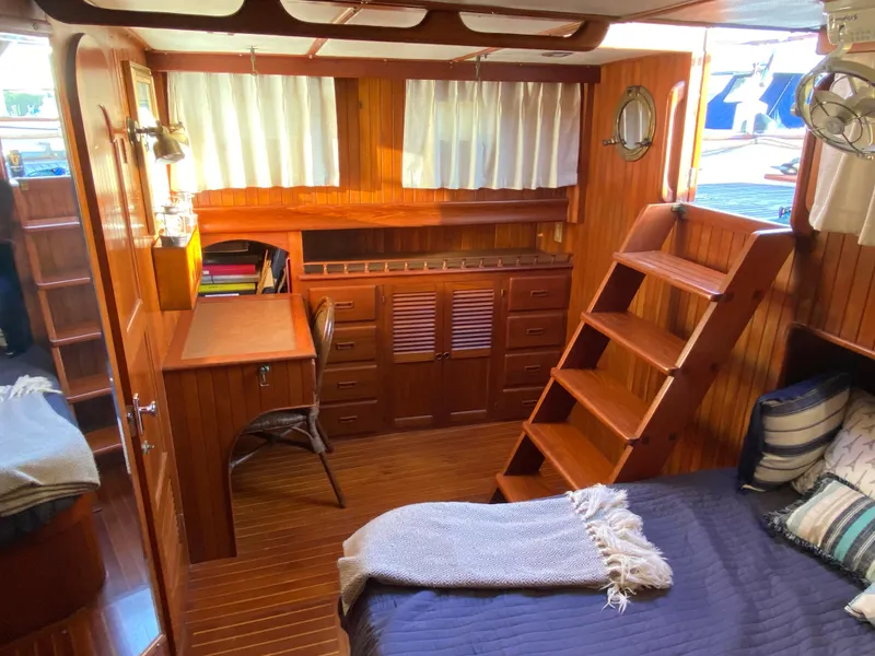 Slide: The Image of Cozy 1983 DeFever 41 yacht interior with wooden decor and comfortable bedding. - 26