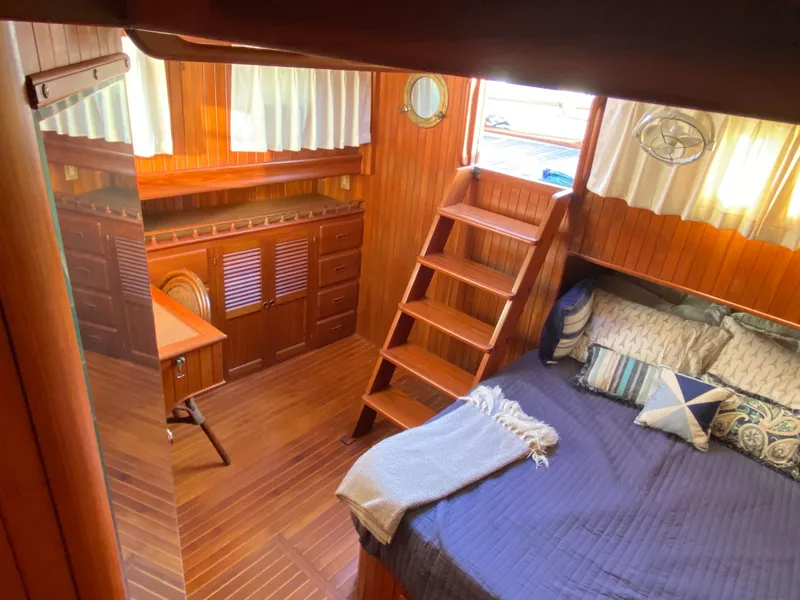 Slide: The Image of 1983 DeFever 41 yacht interior with wooden decor, bed, and stairs. - 28