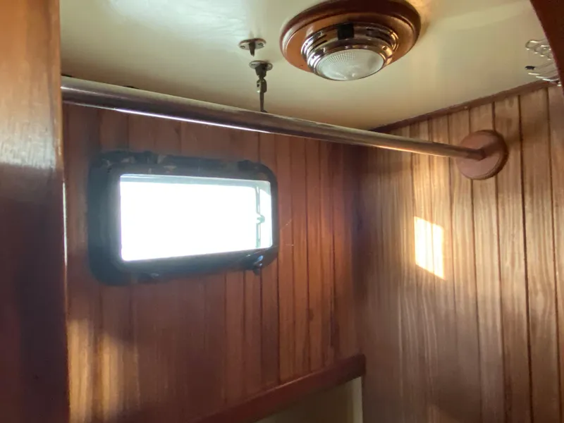 Slide: The Image of Interior of 1983 DeFever 41 boat with wooden paneling and porthole window. - 30