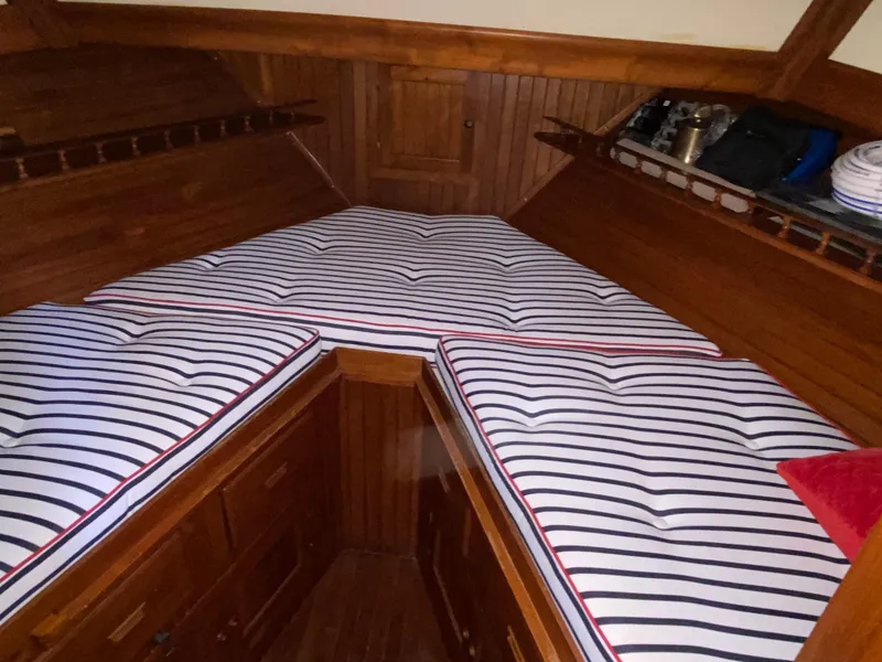 Slide: The Image of 1983 DeFever 41 boat cabin with striped cushions and wooden interior. - 32