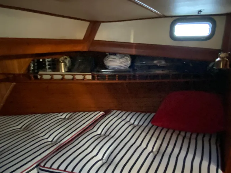Slide: The Image of Cozy cabin interior of 1983 DeFever 41 yacht with striped bedding and wooden accents. - 33