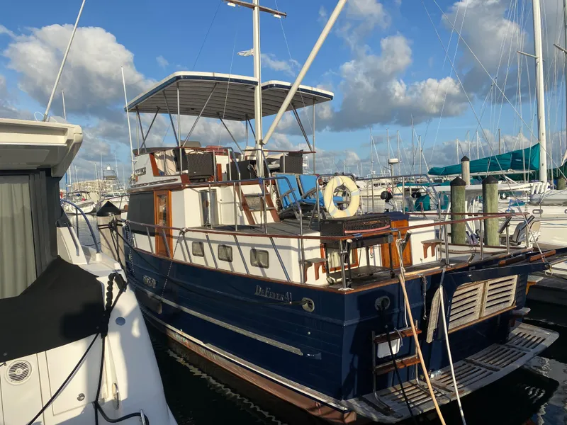 Slide: The Image of 1983 DeFever 41 yacht docked at marina under blue sky. - 4
