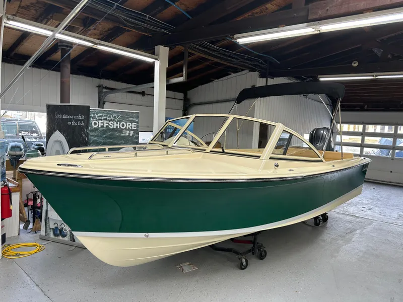Slide: The Image of 2025 Rossiter 20 Day Boat in showroom, green hull, cream interior, under bright lighting. - 0
