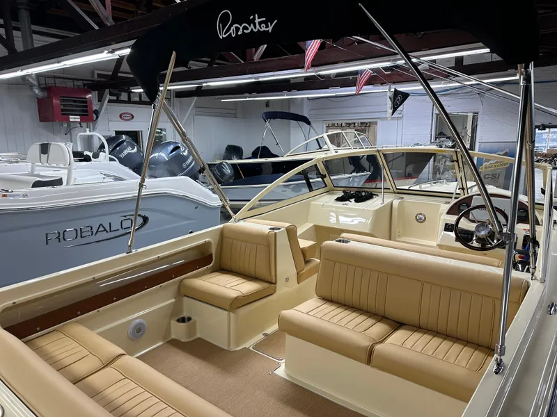 Slide: The Image of 2025 Rossiter 20 Day Boat interior with tan seating and sleek design in showroom. - 10