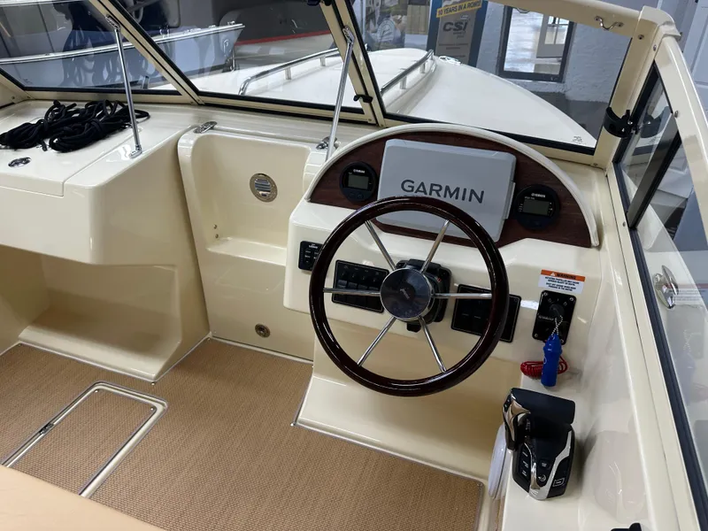 Slide: The Image of 2025 Rossiter 20 Day Boat interior with Garmin navigation system and steering wheel. - 13