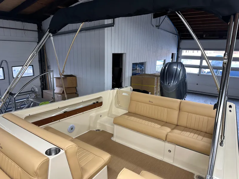 Slide: The Image of 2025 Rossiter 20 Day Boat interior with tan seating in a garage setting. - 4
