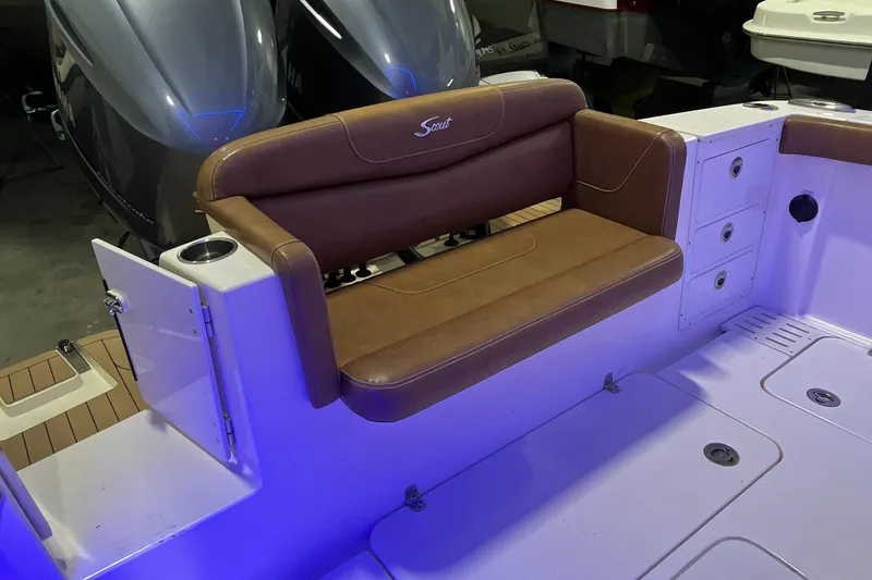 Slide: The Image of 2021 Scout 305 LXF boat with brown leather seating and illuminated deck. - 12