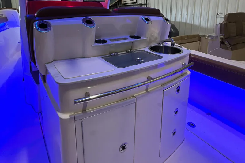 Slide: The Image of 2021 Scout 305 LXF boat interior with illuminated kitchenette and storage cabinets. - 14