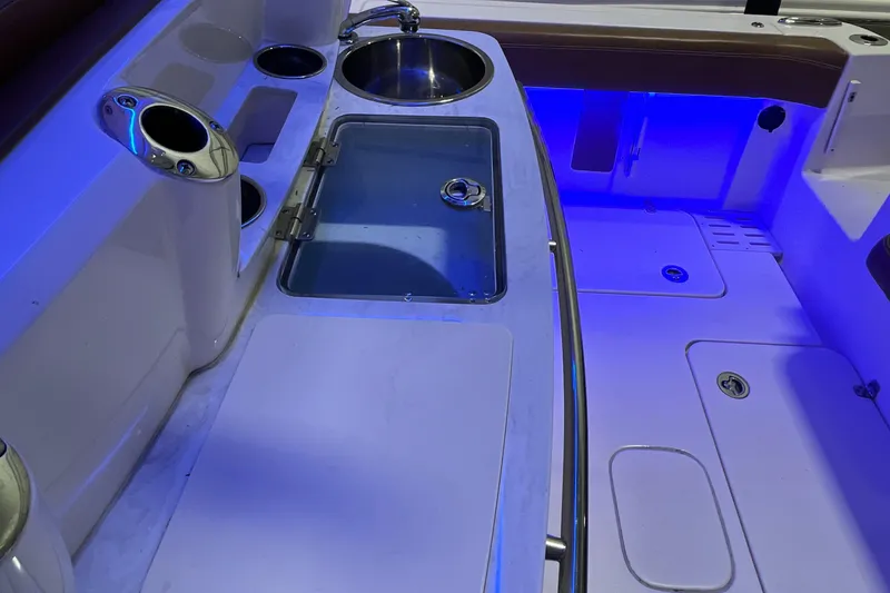 Slide: The Image of 2021 Scout 305 LXF boat interior with sink and blue LED lighting. - 16