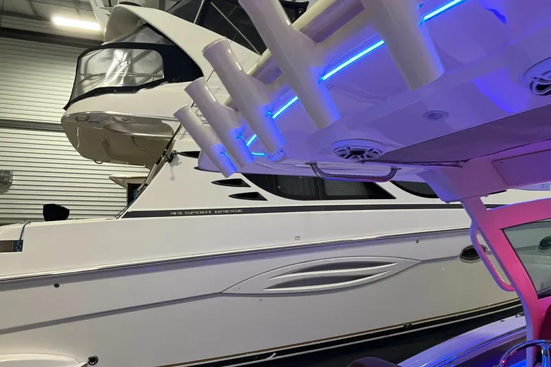 Slide: The Image of 2021 Scout 305 LXF boat in a garage with blue LED lights. - 17