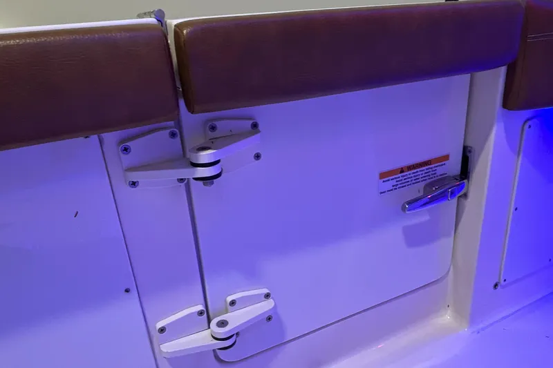 Slide: The Image of 2021 Scout 305 LXF boat interior with cushioned seating and secure latch. - 21