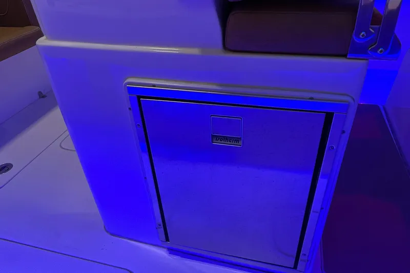 Slide: The Image of 2021 Scout 305 LXF boat interior with blue-lit storage compartment. - 25